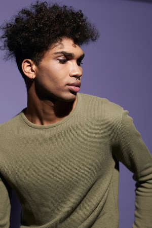 Close-up portrait of youth afroamerican male with curly black hair posing on isolate purple backgroundの写真素材