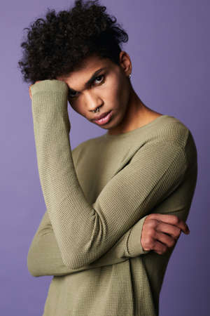 Close up verticale portrait of transgender latin american man on purple backgroundの写真素材