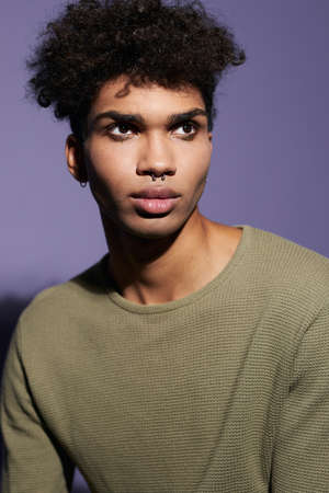 Portrait of young afroamerican transgender man with afro hairstyle and casual dress in studioの写真素材