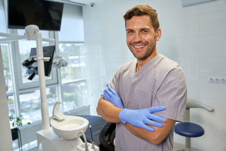 Young ambitious dentist looking happy about his workplaceの写真素材