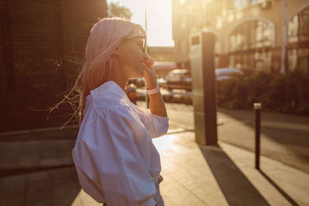 Cheerful young woman standing on the streetの写真素材