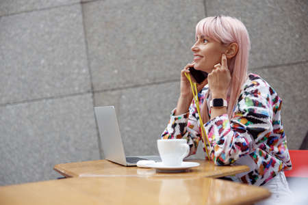 Woman having a phone call at table of cafe terraceの写真素材