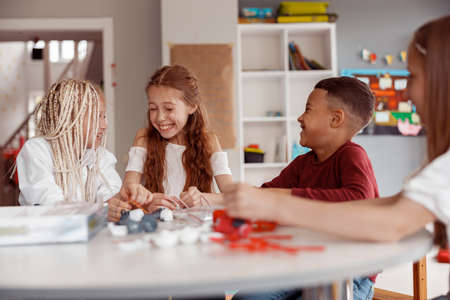Smiling kids creating diy construction at the desk in schoolの写真素材