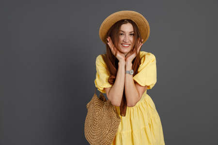 Cheerful woman in yellow dress standing in studioの写真素材