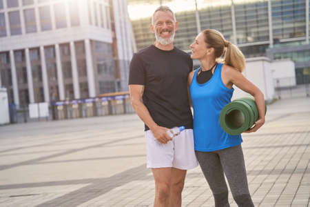 Happy mature couple, man and woman in sportswear posing together after morning workoutの写真素材