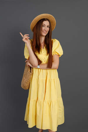 Joyful woman in yellow dress standing in studioの写真素材