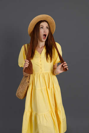 Shocked woman in yellow dress standing in studioの写真素材