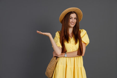 Attractive woman in yellow dress standing in studioの写真素材
