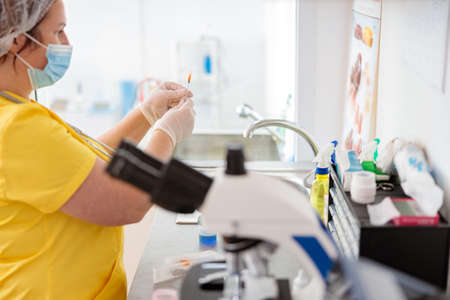 Woman veterinarian examines blood test in laboratoryの写真素材