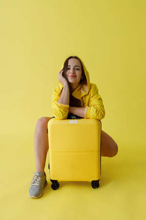 Charming woman with travel bag posing in studioの写真素材
