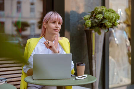Young woman using notebook at outdoor cafeの写真素材