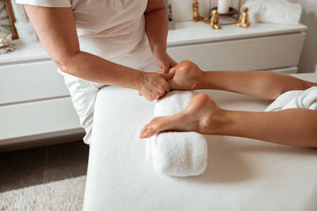 Female client receiving foot massage in spa salonの写真素材