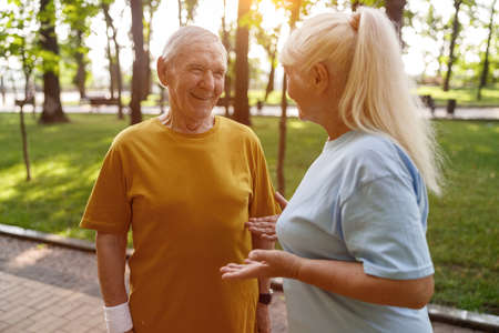 Sportive senior man and woman communicate at training in parkの写真素材