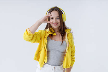 Charming woman in headphone doing half heart symbolの写真素材