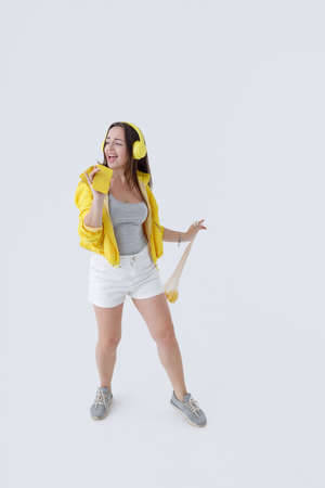 Pretty woman listening to music and singing into smartphoneの写真素材
