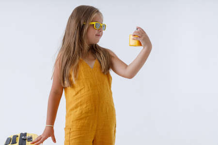 Adorable little girl in sunglasses holding perfumeの写真素材