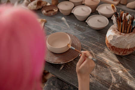 Young female potter engaged in craft in her workshopの写真素材