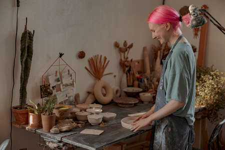 Young female potter engaged in craft in her workshopの写真素材