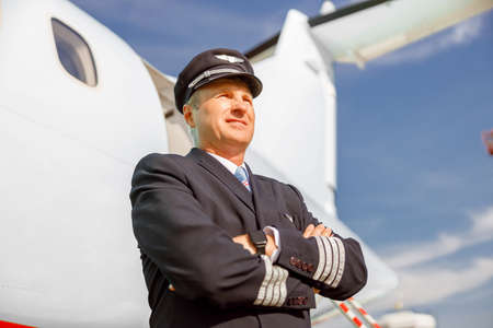 Man airplane pilot standing outdoors at airportの写真素材