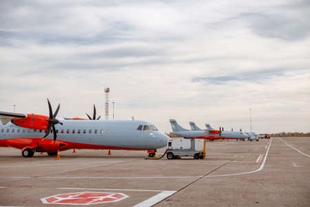Passenger airplanes and private jets parked at airfieldの写真素材