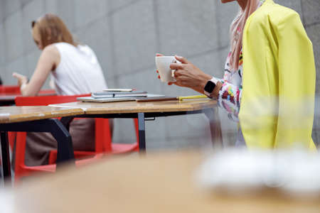 Person drinking coffee in open air at cafe tableの写真素材