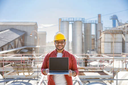 Experienced engineer with hard hat in factoryの写真素材