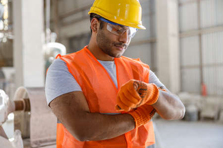 Young worker dressed in safety equipment inside factoryの写真素材