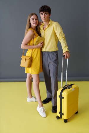 Beautiful couple with travel suitcase standing in studioの写真素材