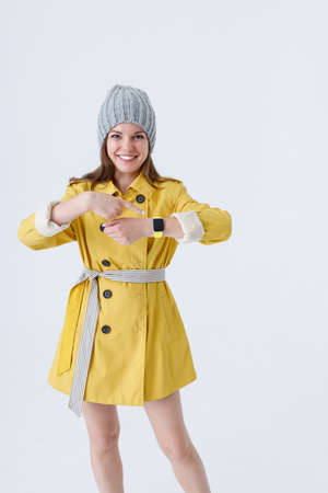 Cheerful young woman pointing at her smart watchの写真素材