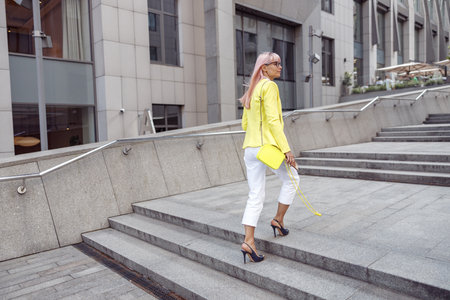 Female with pink hair going up city stairsの写真素材