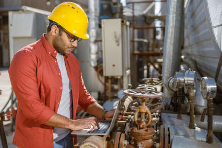 Skillful multiethnic engineer working at heavy industry plantの写真素材