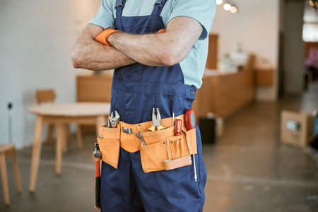 Male builder wearing tool belt with instrumentsの写真素材