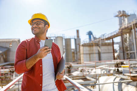 Multiracial construction engineer leading production process outdoorsの写真素材