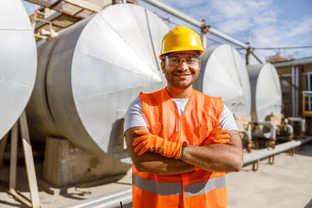 Smiling African engineer standing at industrial siteの写真素材