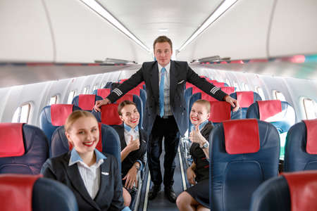 Male pilot and stewardesses in passenger airplane cabinの写真素材