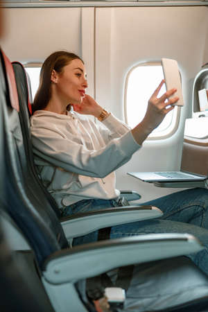 Young woman making selfie in passenger airplaneの写真素材