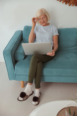 Pensioner female sitting on sofa at homeの写真素材