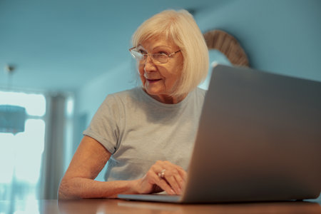 Senior woman resting with laptop at homeの写真素材