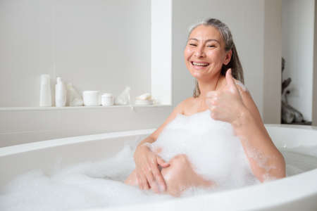 Positive asian lady resting in the hotelの写真素材