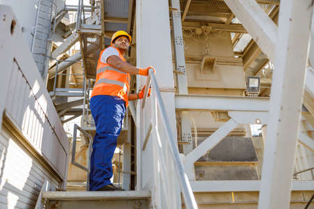Serious African engineer standing at industrial siteの写真素材