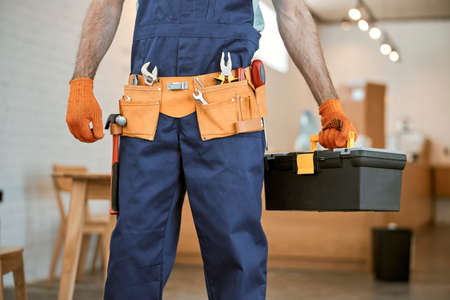 Male electrician in gloves holding tool box setの写真素材