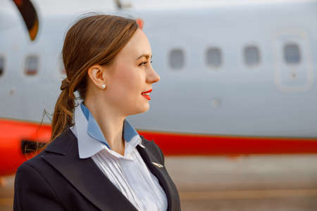 Female flight attendant standing outdoors at airfieldの写真素材