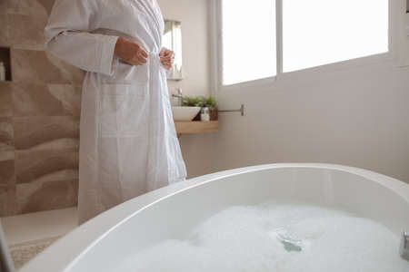 Adult woman getting ready to take bathの写真素材