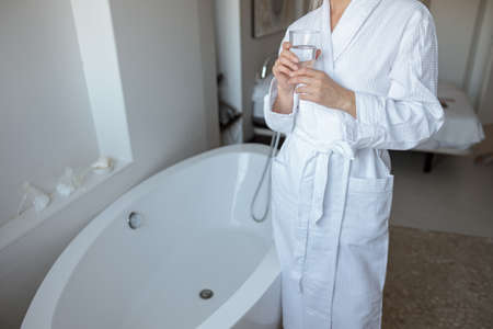 Woman standing near the buthtub in hotel room