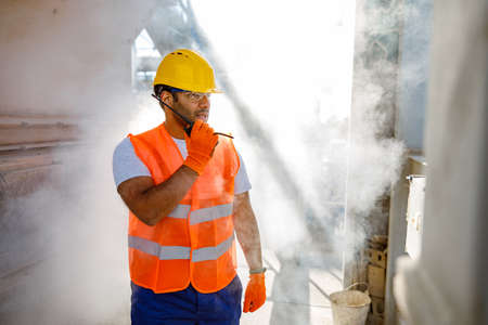 Skillful multiethnic engineer working at construction plantの写真素材