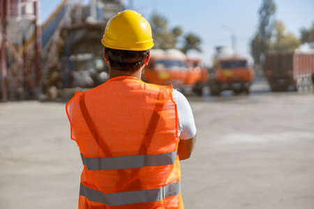 Confident construction worker controlling production process outdoorsの写真素材