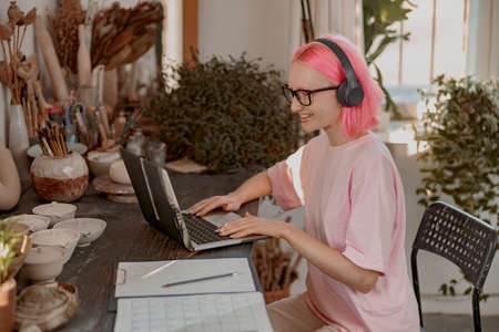 Cute female potter involved in work in her workshopの写真素材