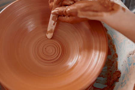 Handmade artist creating earthen bowl on circle in art studioの写真素材