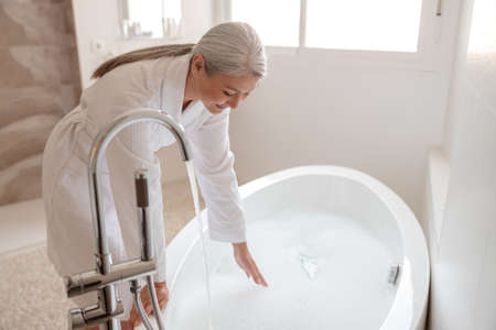 Asian lady getting ready to take bathの写真素材