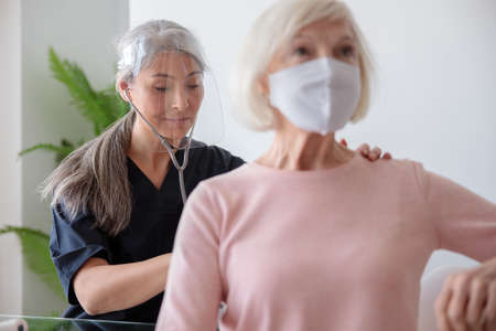 Doctor visiting senior patient at home appointment